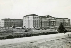 black and white building with people and vehicles